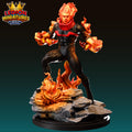A figurine of a fiery, muscular character with flames emanating from its head and body, standing on a rocky base.