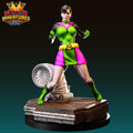 A 3D printed figurine of a female superhero character in a green and pink costume, standing on a platform and holding a weapon.