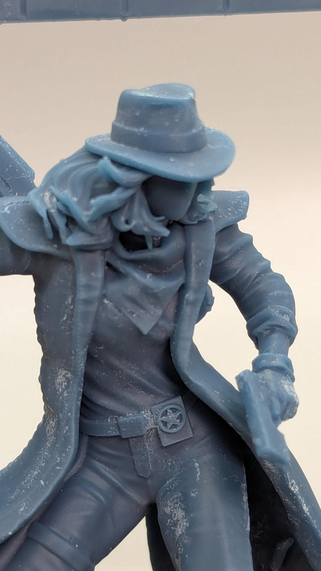 A close-up view of a figurine depicting a person wearing a hat and holding a gun.