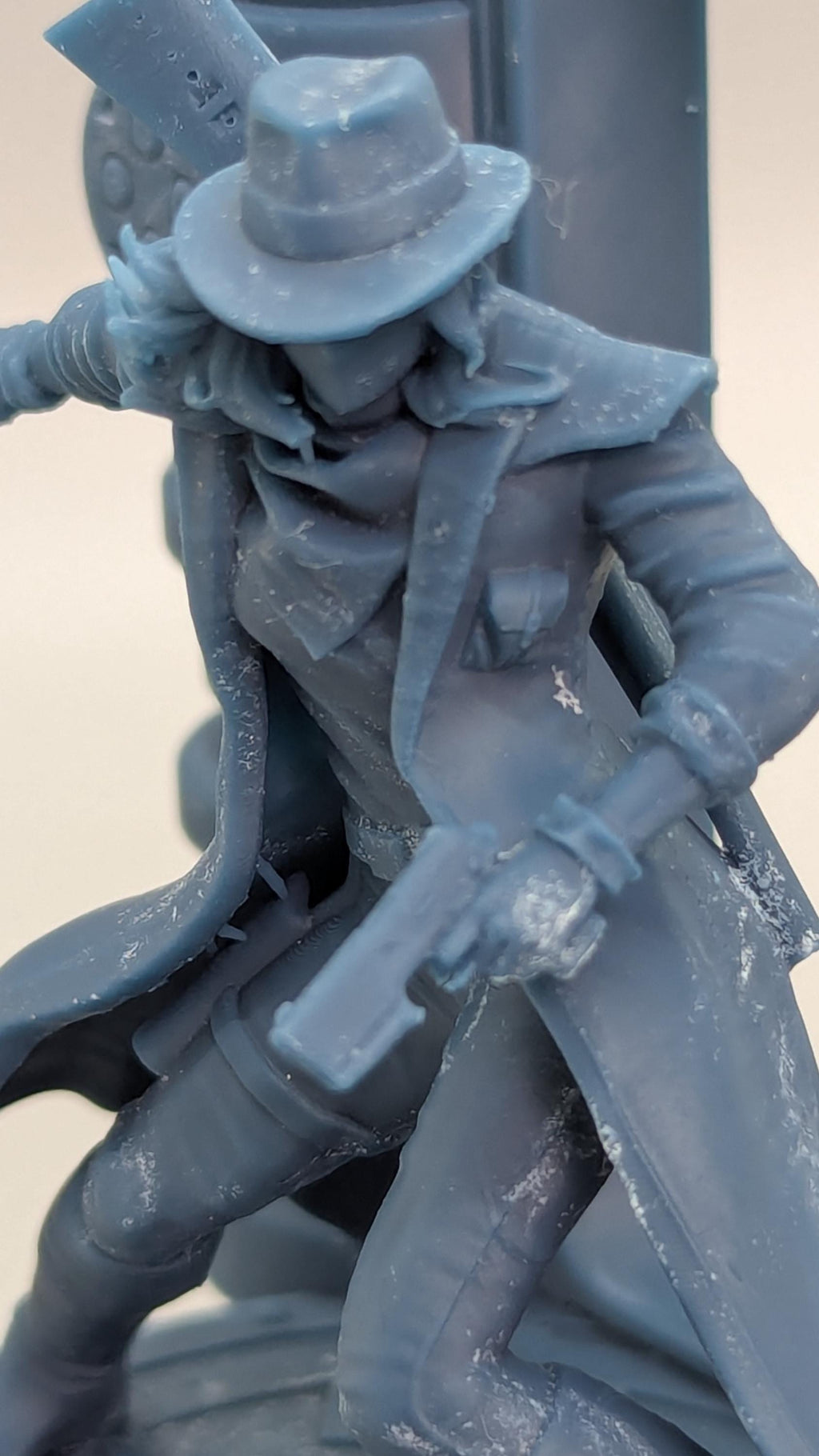 A close-up view of a figurine or statue depicting a person wearing a hat and holding a weapon.