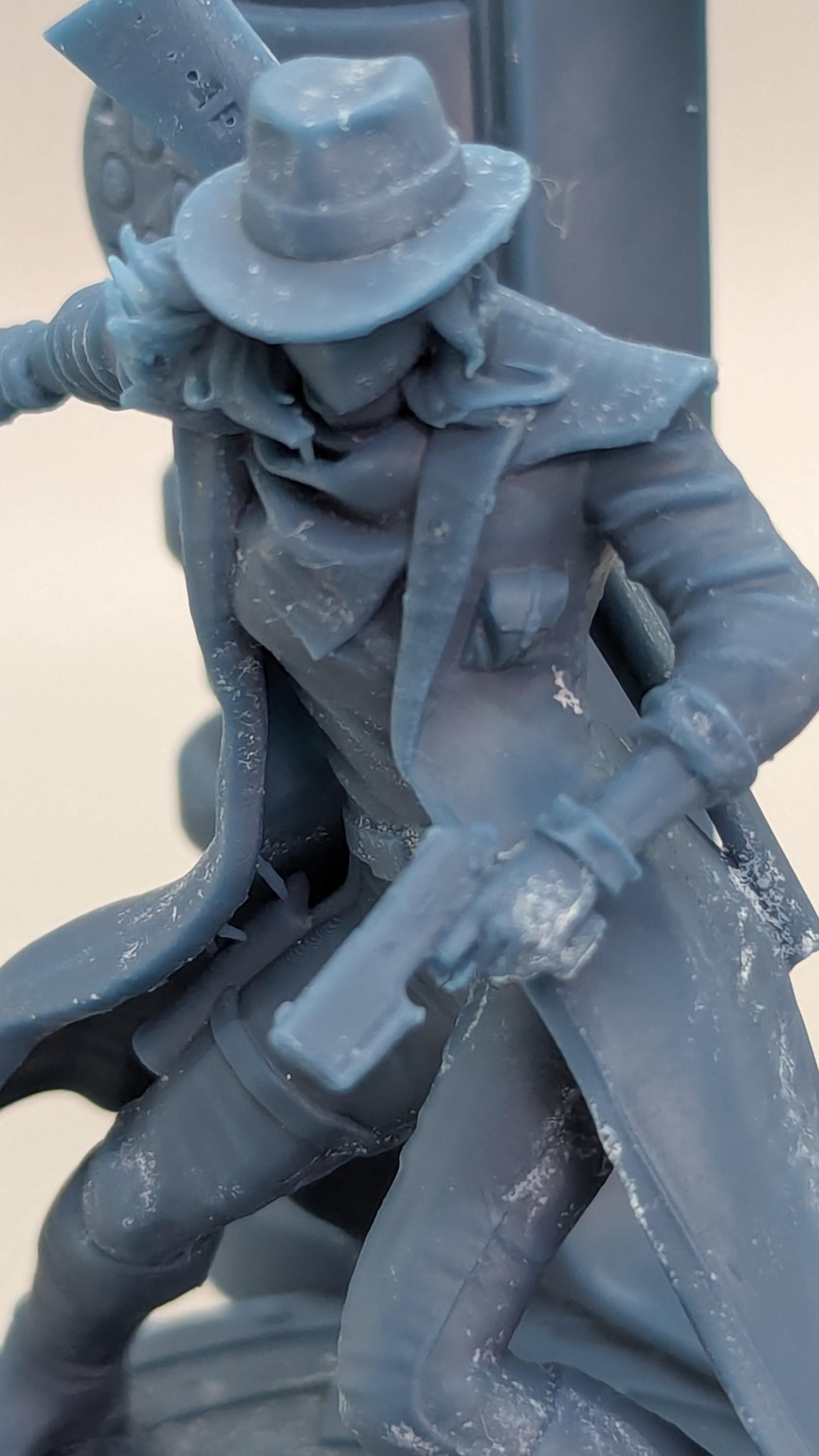 A close-up view of a figurine or statue depicting a person wearing a hat and holding a weapon.