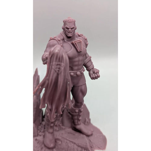A close-up image of a figurine of a muscular, armored figure with a cape-like design on the back, standing on a rocky surface.